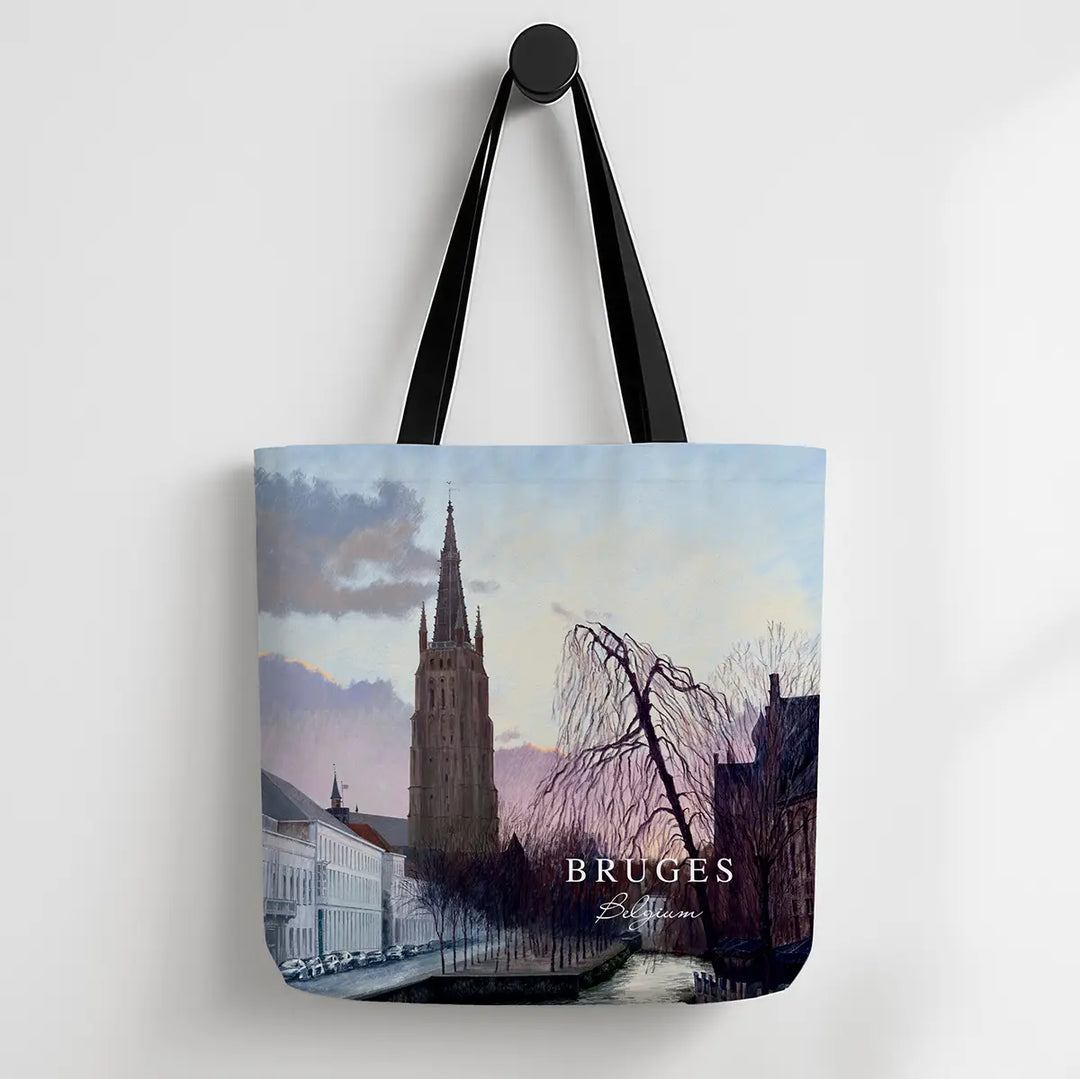 Tote bag with a scenic design of Bruges featuring a tall tower and canal.