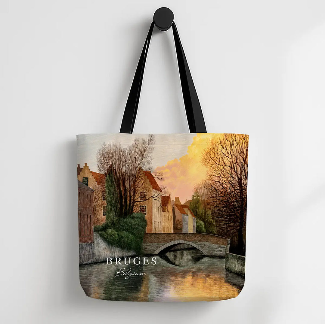 Tote bag with a scenic design of Bruges, featuring a bridge over water and buildings.