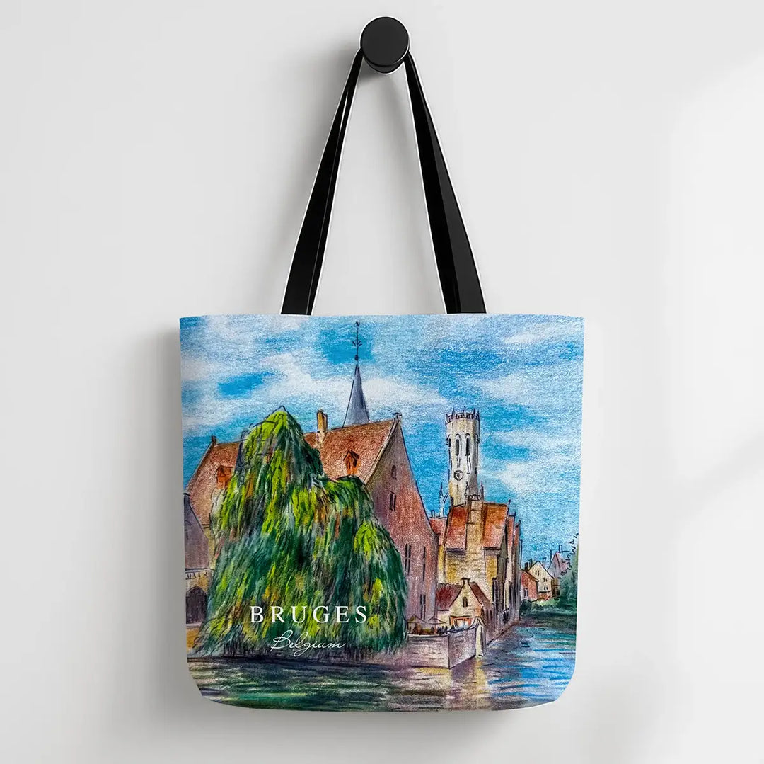 Tote bag with a scenic design of Bruges, featuring buildings and a river.