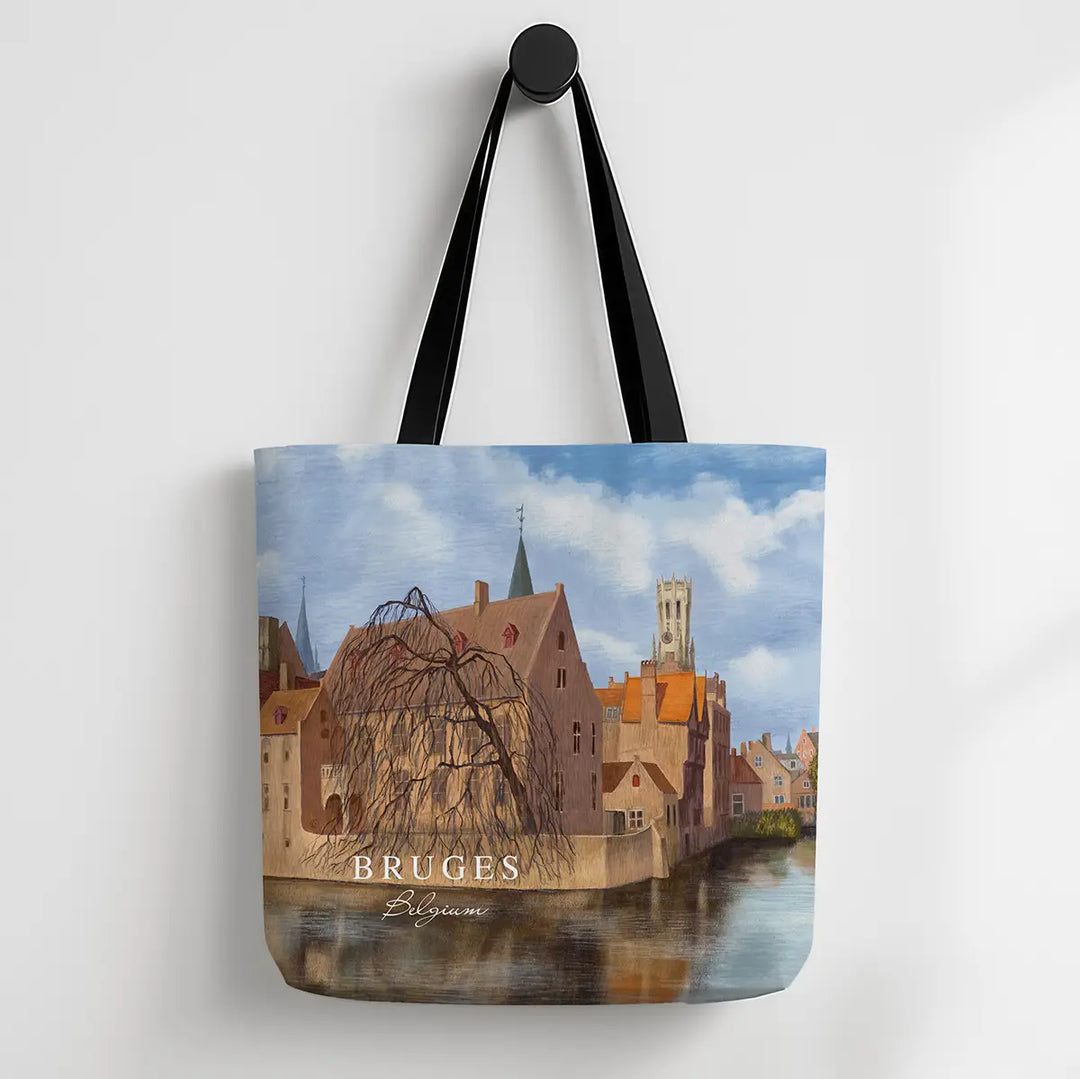 Tote bag with a scenic design of Bruges, featuring buildings and a river.