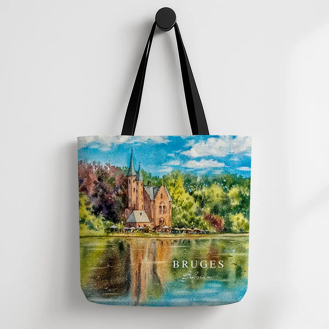 Tote bag with a scenic design of a castle by a lake and the word 'Bruges' on a white background.