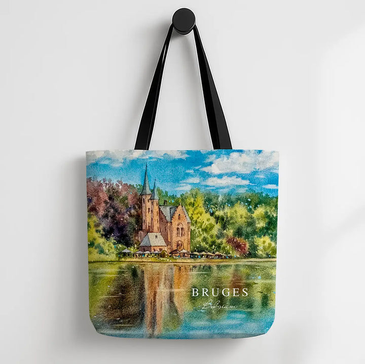 Tote bag with a scenic design of a castle by a lake and the word 'Bruges' on a white background.