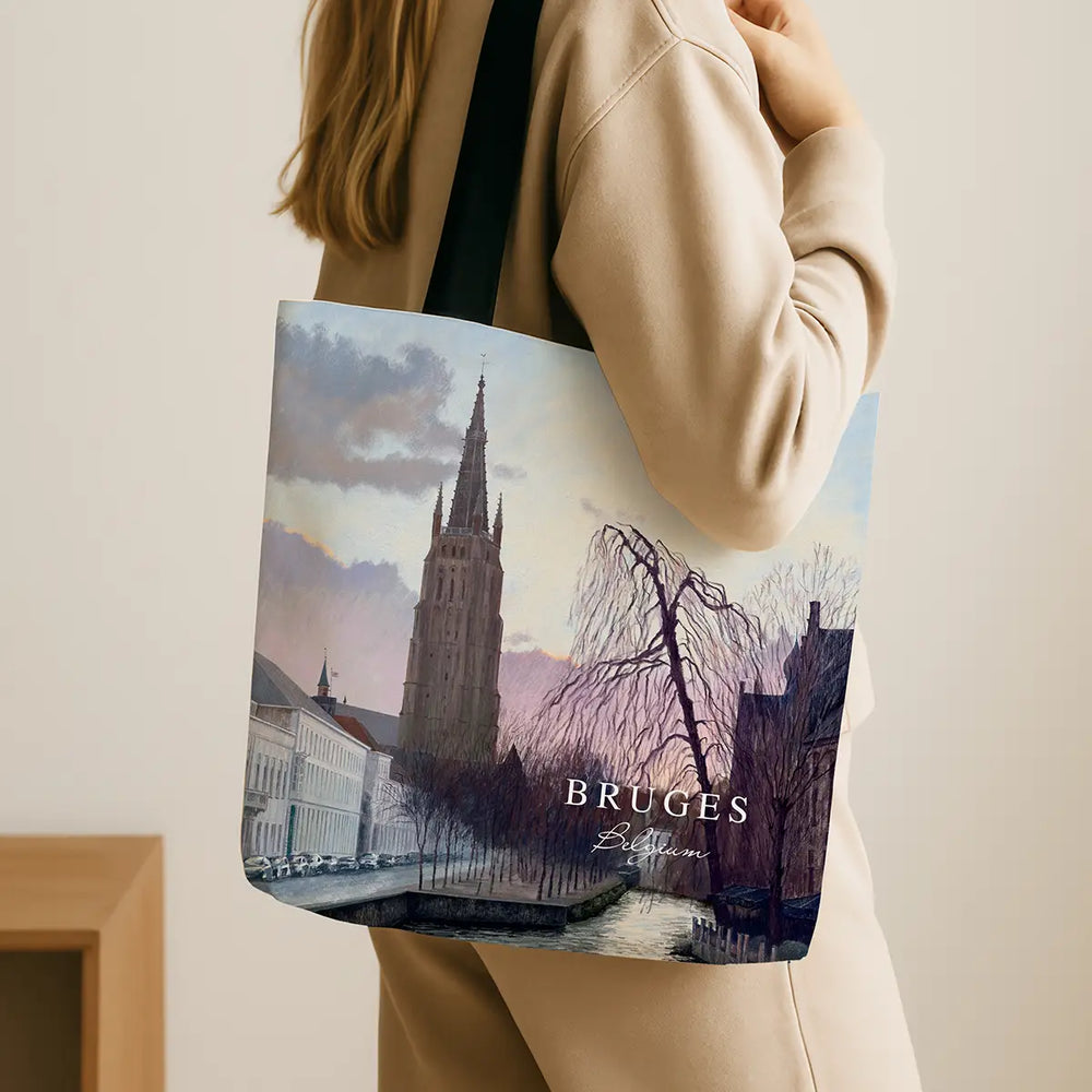 Tote bag with a scenic design of Bruges, held by a person.