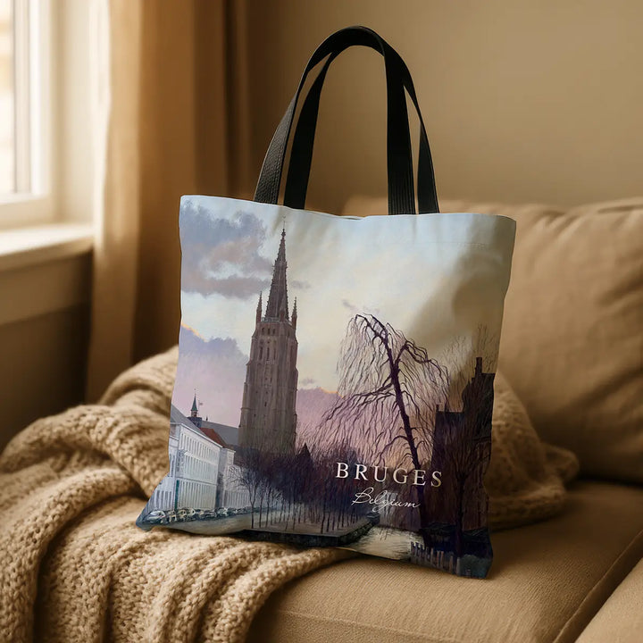 Tote bag with a scenic design of Bruges, Belgium, on a couch.