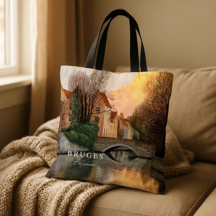 Tote bag with a scenic design of Bruges, Belgium, on a couch.