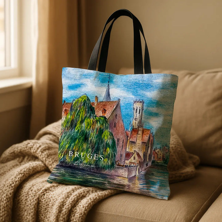 Tote bag with a scenic design of Bruges on a beige couch.